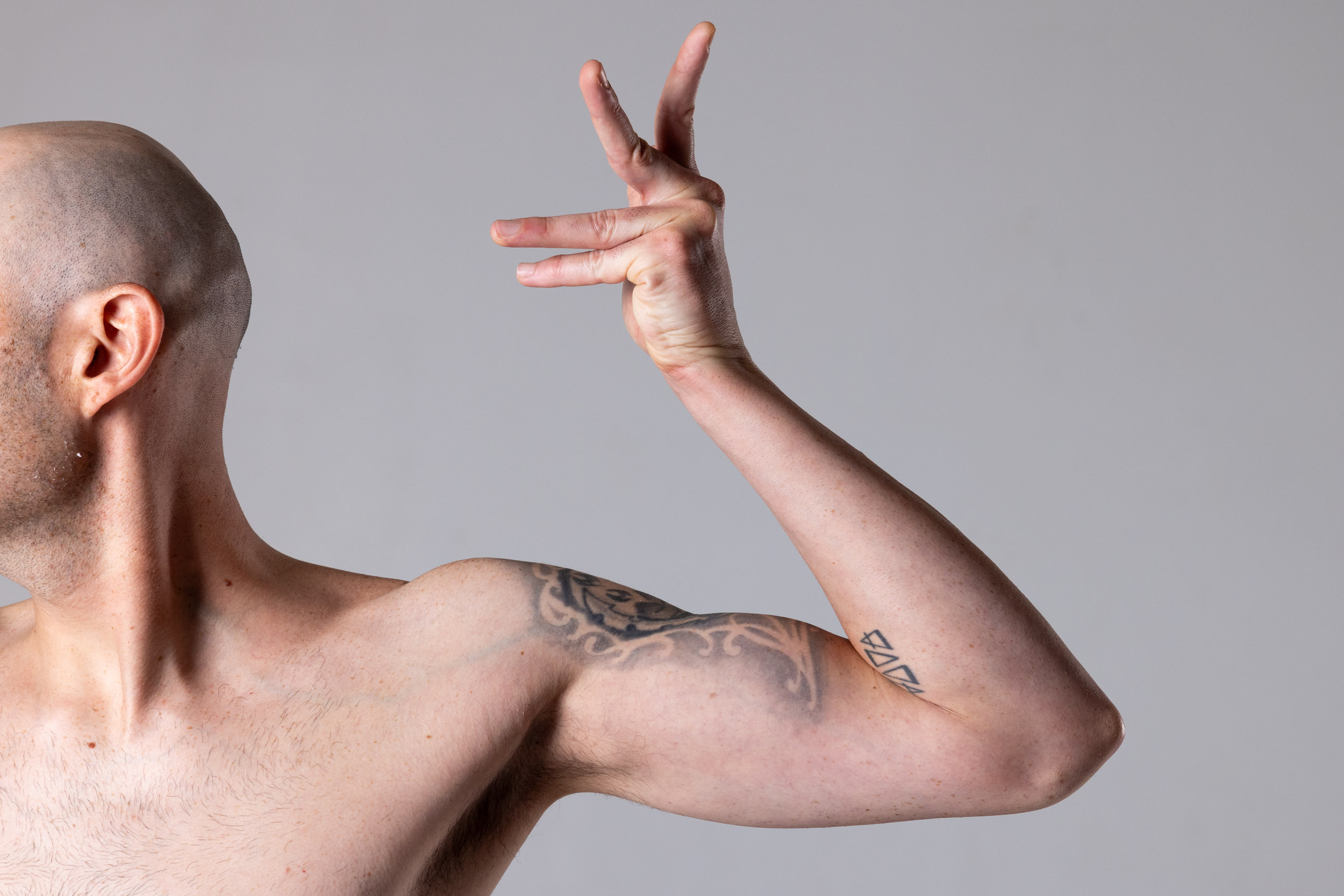 Raised arm anatomy crop showing the elbow bend, forearm line, and hand shape