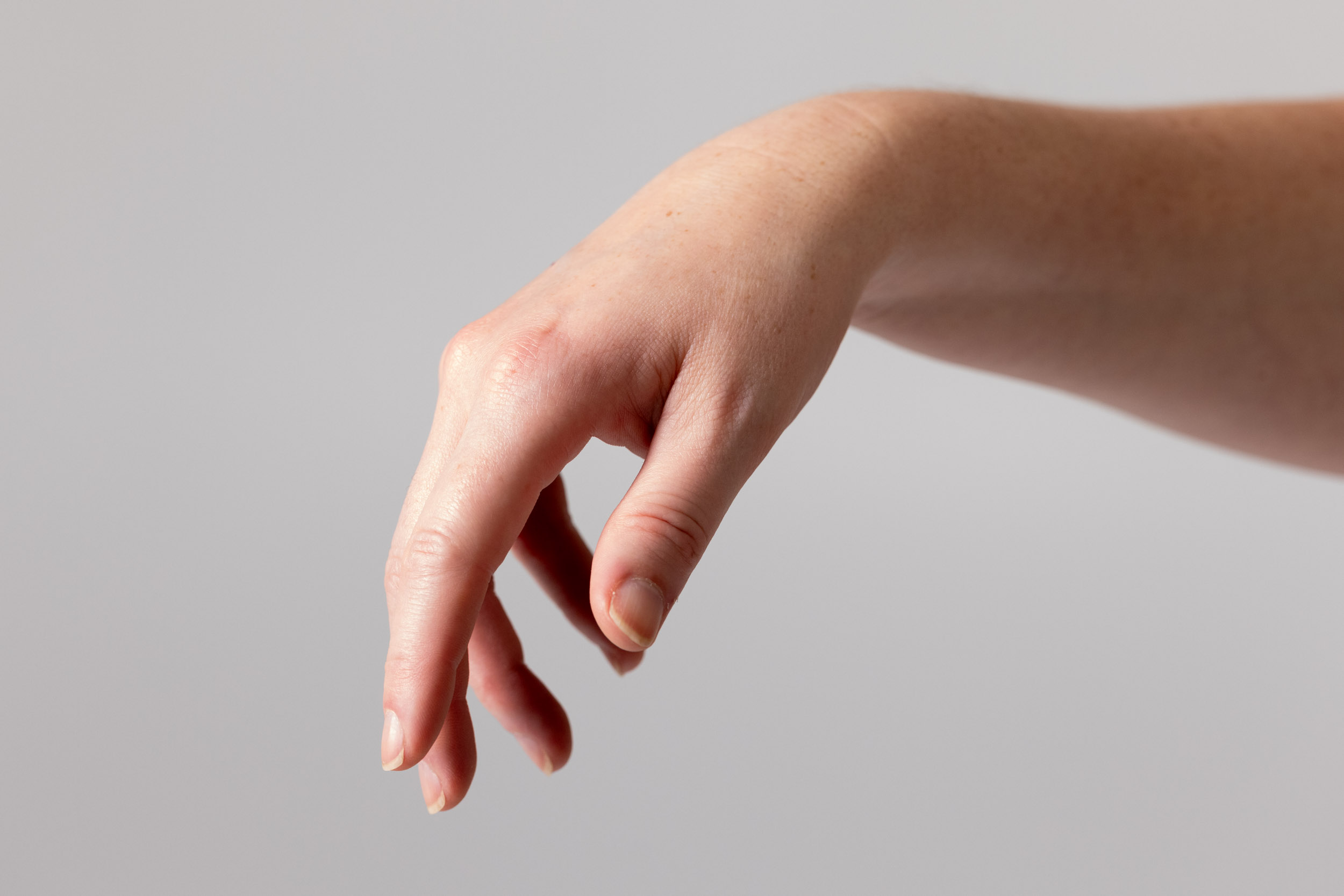 Close-up hand gesture reference with a relaxed wrist and hanging fingers