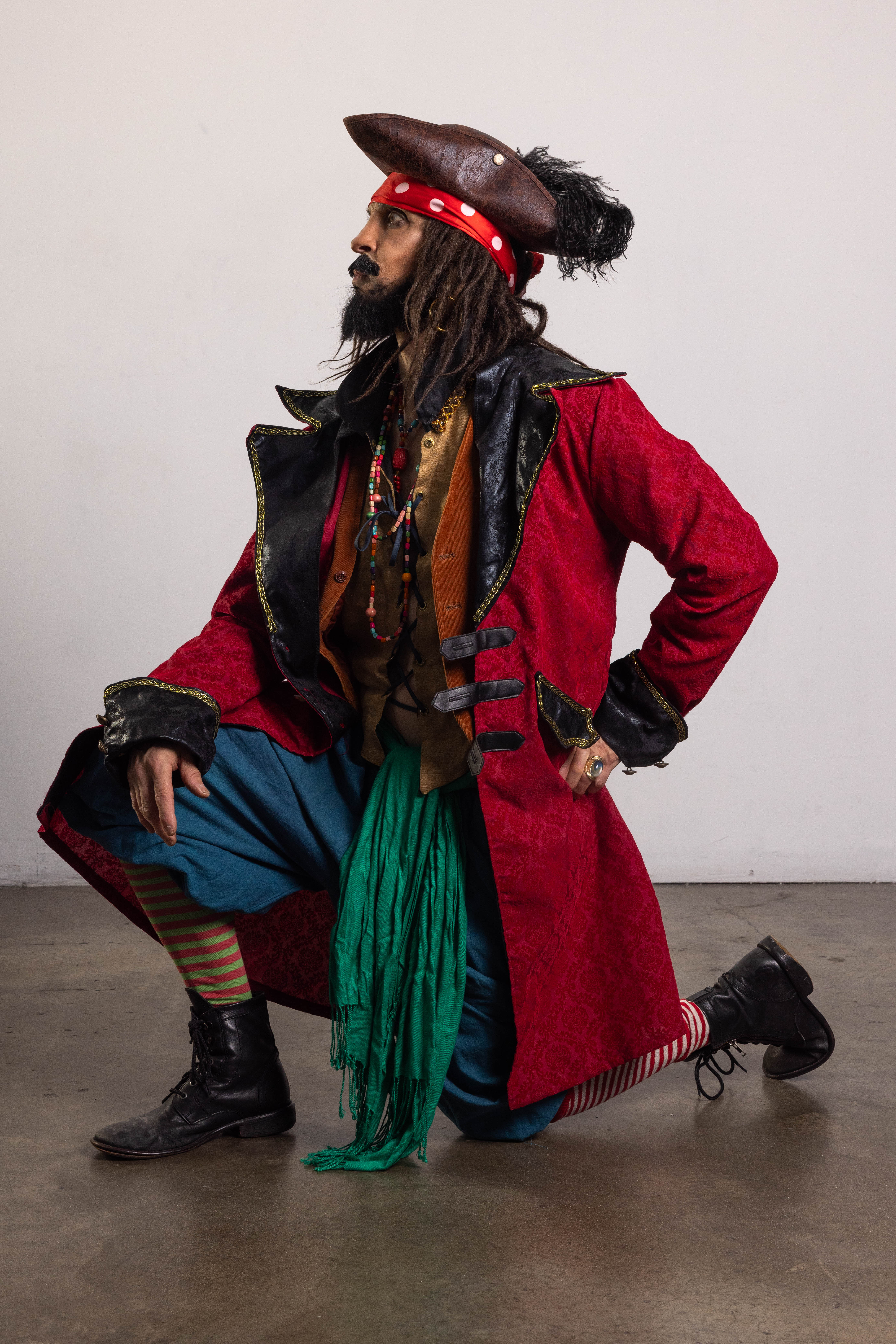 Kneeling pirate costume pose reference in profile with one hand on the hip